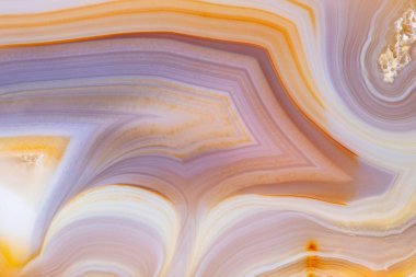 Doğal agat dilimi. Çizgili agat, düzenli olarak dekoratif desenlerde düzenlenmiş harika renkli çizgilerle karakterize edilen çeşitli çakmaktaşların varyasyonudur..