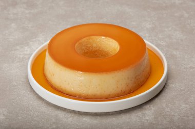 Yoğunlaştırılmış süt pudingi ve yumurta sarısı. Lezzetli damlayan şurupla birlikte, ev yapımı. Mermer bir masada..