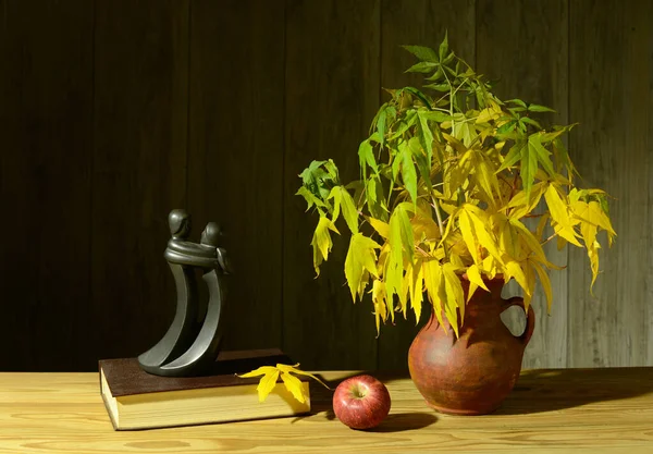 桌上放着苹果和陶瓷花瓶的静谧生活 图库图片