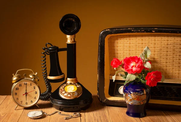 テーブルの上の古いライン電話 古いラジオ 時計とのまだ生命 ストック写真