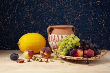 Hayat, balkabakları, seramik demlik ve masada çeşitli meyveler.