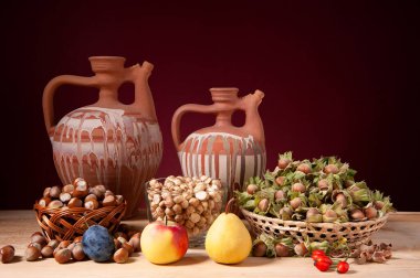 Hayat, fındık, elma, armut, erik ve seramik sürahiler ahşap bir masada