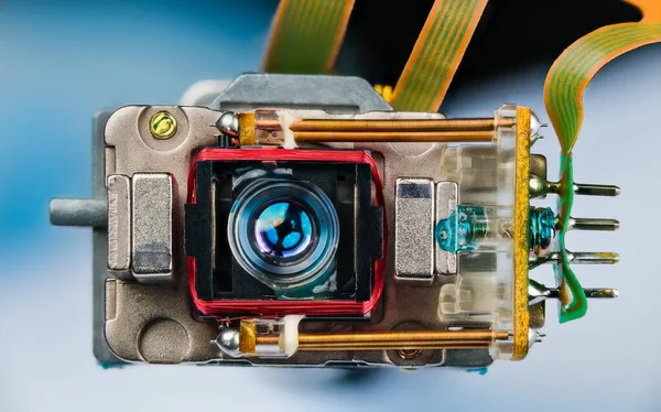 Elektronik esneklik kablolarına bağlı küçük bir optik okuma yazma merceği kapat. Bakır sarmalı lazer aleti, kalıcı neodim mıknatıslar ve bobin yayları. Bir CD DVD disk sürücüsünün parçası.