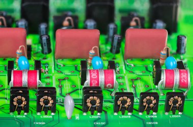 Dijital telefon değiş tokuşu analog bölümünün dalgalanma korumasında çeşitli elektronik bileşenler. Siyah çantada boğulmalar, kırmızı elektrot tutuklaması gaz boşaltma tüpleri veya yeşil PCB 'de polyester film kapasitörleri.