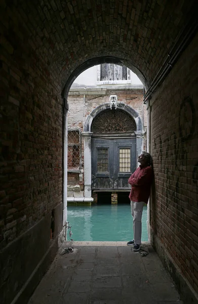 運河に面した小さな路地でヨーロッパ人男性 ヴェネツィアイタリア — ストック写真