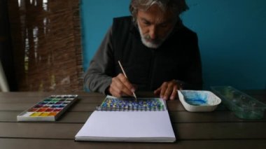 İş yerindeki sanatçı Spiral çiçekli suluboya, fırça renkleri