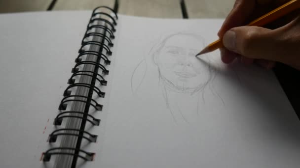 鉛筆でスケッチブックに描く男は — ストック動画