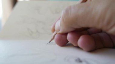 hand holding pencil, artist at work detail