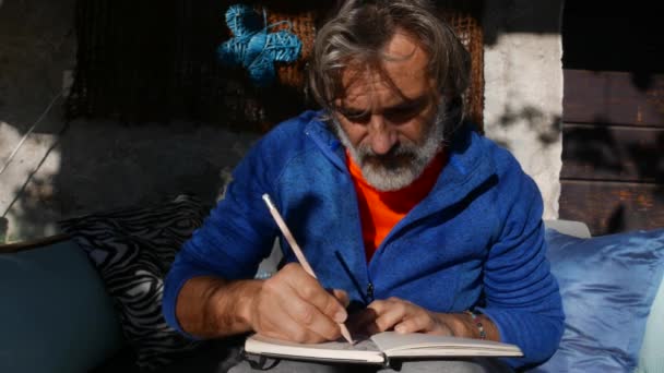 Pensive Mature Man Drawing Sketchbook Outdoor — Video