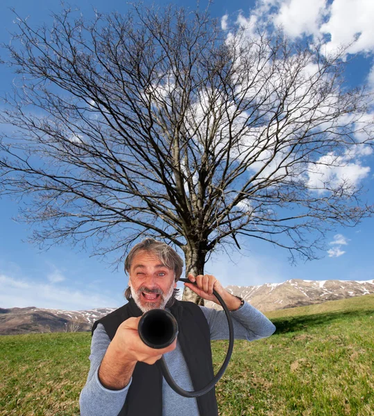 Deaf concept, caucasian man with vintage device over beautiful countryside