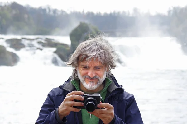 スイスのラインフォールに対する中年の写真家の肖像画 — ストック写真