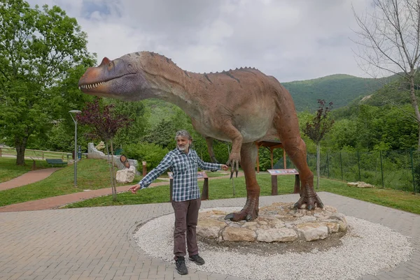 Mężczyzna Obok Rzeczywistej Wielkości Posągu Dinozaura Saltriovenator Który Żył Podczas — Zdjęcie stockowe