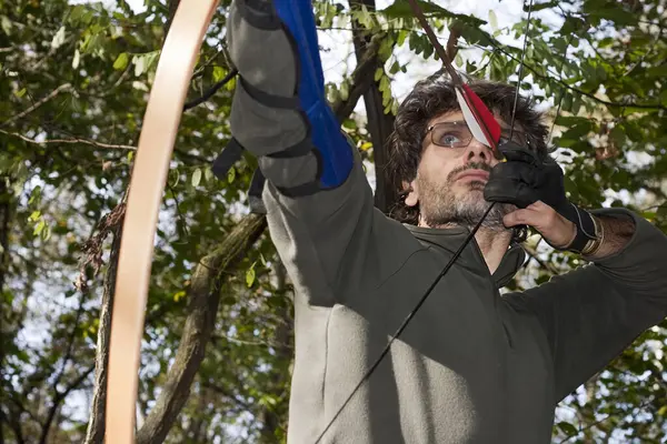 Okçuyu ormanda geleneksel uzun yay ile hedeflemek. 