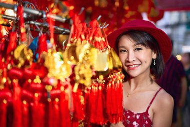 thai woman posing with good luck charms at yaowarat china town in bangkok thailand during chinese new year