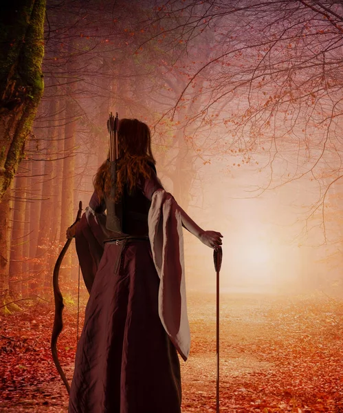 一个红头发的中世纪女弓箭手 在秋天的森林里带着弓箭 幻想世界3D渲染 图库照片