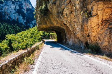 Yunanistan 'ın Moreloponnese kentindeki eski Sparta-Kalamata otobanındaki kayaların altındaki muhteşem yol. Bu yol iki tarihi şehri, Sparta ve Kalamata 'yı birbirine bağlıyor ve Taygetos dağ sırasını ve çevresindeki kırsal bölgeleri nefes kesici bir şekilde gösteriyor..