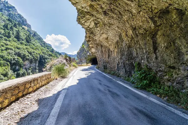 希腊伯罗奔尼撒斯巴达 卡拉马塔公路的岩石下的华丽的道路 这条公路连接斯巴达和卡拉马塔这两个历史名城 可以俯瞰泰姬陵山脉和周围的乡村美景 图库照片