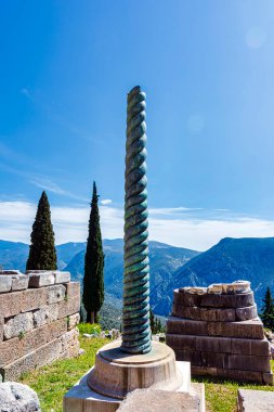 Serpent Column of Plataea or Delphi Tripod in front of the Temple of Apollo in Delphi, Greece, an ancient sanctuary clipart