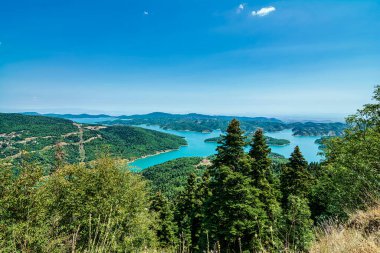 Idyllic landscape on the lake of Plastiras in central Greece. Lake Plastiras is an artificial lake fed by Tavropos river, located in Karditsa regional unit, near the city of Karditsa, Greece. clipart