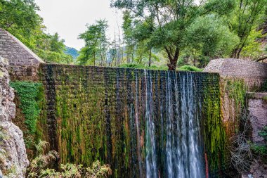 Eski bir taş köprü ve Paleokaria, Trikala, Yunanistan 'da güzel bir şelale. Paleokaria 'nın muhteşem köprüsü 16. yüzyıldan beri orada duruyor..