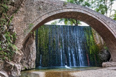 Eski bir taş köprü ve Paleokaria, Trikala, Yunanistan 'da güzel bir şelale. Paleokaria 'nın muhteşem köprüsü 16. yüzyıldan beri orada duruyor..