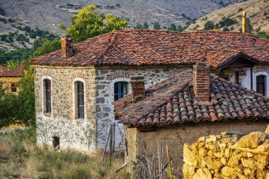 Yunanistan 'ın Agios Germanos kentindeki geleneksel kırmızı kiremit çatılı ve bacalı eski taş evleri, kırsal mirası ve dağ köyündeki yaşamı yansıtıyor..