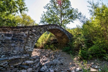 Yunanistan 'ın Epirus kentindeki bereketli yeşilliklerle çevrili antik taş kemer köprüsünde geleneksel mimari ve doğal güzellikler sergileniyor.