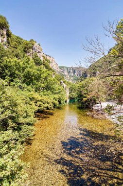 Yunanistan 'ın Zagori kentindeki Vikos Vadisi' nin yemyeşil sularından akan Voidomatis Nehri 'nin berrak suları sarp kayalıklarla çevrilidir..