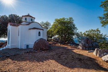 Yunanistan 'ın Maniaki kentinde, ağaçlar ve güneş ışığıyla çevrili kayalık arazide, geleneksel Yunan mimarisi ve ruhaniliğini yansıtan tuhaf bir beyaz şapel bulunuyor..
