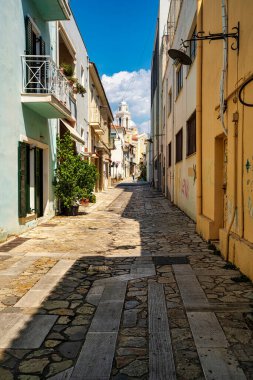 Yunanistan 'ın Kalamata kentinde taş kaldırımları ve uzaktaki Ypapanti Metropolitan Kilisesi manzaralı büyüleyici dar bir cadde..