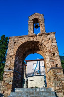 Yunanistan 'ın Christianoupolis kentindeki tarihi bir taş çan kulesi. Güneş ışığıyla aydınlatılarak geleneksel Bizans mimari unsurları sergileniyor..
