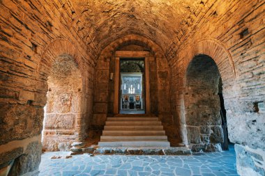 View through a stone archway into the interior of a Byzantine church in Christianoupolis, Greece, highlighting the altar and icons. clipart