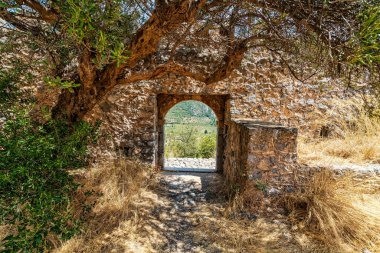 Kapetanakis Kulesi 'nin harabelerinde taş kemer, Messinia, Yunanistan, antik duvarları çerçevelemek ve manzaralı tarihi bir manzara.