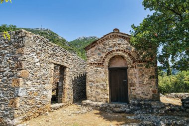 Yunanistan 'ın Sotirianika kentindeki küçük Bizans tarzı Agia Kyriaki kilisesi taş harabeleri ve yemyeşil dağ manzaralarıyla çevrili..