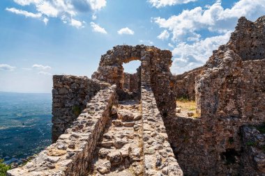 Yunanistan 'ın Mystras kentinin kalıntılarının tepesinde yıkılan bir taş kemer aşağıdaki vadiyi büyüleyici bir şekilde gösteriyor..