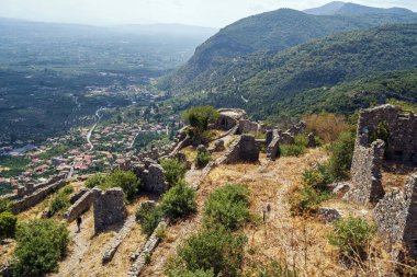 Yunanistan 'ın Mystras kentinin antik kalıntıları, vadi ve dağların panoramik manzaralarıyla bir yamaç boyunca dağıldı..