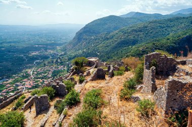 Yunanistan 'ın Mystras kentinin antik kalıntıları, vadi ve dağların panoramik manzaralarıyla bir yamaç boyunca dağıldı..