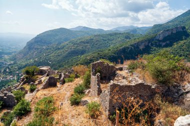 Yunanistan 'ın Mystras kentinin antik kalıntıları, vadi ve dağların panoramik manzaralarıyla bir yamaç boyunca dağıldı..