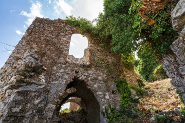 Yunanistan 'ın Mystras kentindeki aşırı gelişmiş harabeler, sarmaşık kaplı taş duvarlar ve zamansız tarih duygusunu çağrıştıran kavisli açıklarla dolu.
