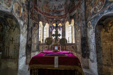 Mystras 'daki Aziz Demetrius Kilisesi' nin süslü sunağında dini kalıntılar, bir haç ve Bizans freskleri yer alıyor..