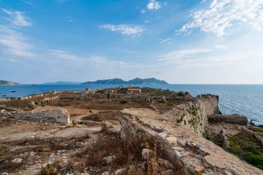 Arka planda Methoni Kalesi, Agios Nikolaos Kilisesi ve Sapientza Adası 'nın bulunduğu panoramik bir manzara..