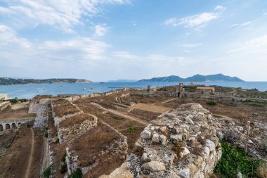 Arka planda Methoni Kalesi, Agios Nikolaos Kilisesi ve Sapientza Adası 'nın bulunduğu panoramik bir manzara..