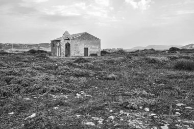 Methoni Kalesi 'nin içinde yer alan Agios Nikolaos Kilisesi' nin siyah-beyaz görüntüsü, engebeli bitki örtüsü ve tarihle çevrili..