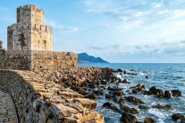 Methoni Kalesi 'ndeki ikonik Bourtzi Kulesi, engebeli kayalar ve İyon Denizi ile çevrili, Venedik mimarisi ve kıyı güzelliğini gözler önüne seriyor..