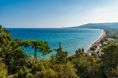 Turkuaz suları, kumlu plajları, yemyeşil ve berrak bir gökyüzü altında yuvarlanan tepeleri olan Koroni kıyı şeridinin manzarası..