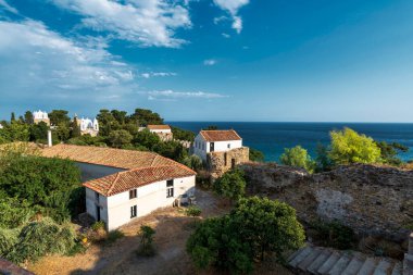 Koroni 'deki Iera Moni Timiou Prodromou manastır kompleksinin sakin manzarası, kiremitli çatılar, yemyeşil alanlar ve Akdeniz.