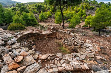 Yunanistan 'ın Lavrion kentinde taş yapılar, kazı çukurları ve çevreleyen yeşil arazilerin yer aldığı antik gümüş madencilik sahasının kalıntıları.