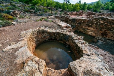 Yunanistan 'ın Lavrion kentinde taş yapılar, kazı çukurları ve çevreleyen yeşil arazilerin yer aldığı antik gümüş madencilik sahasının kalıntıları.