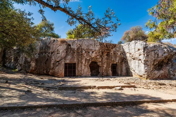 Yunanistan 'ın Atina kentindeki Philopappou Tepesi' nde yer alan Sokrates Cezaevi olarak bilinen antik kaya kesim odasının etrafı çam ve zeytin ağaçlarıyla çevrili..