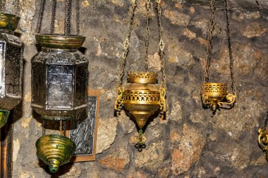 Bizans tütsü lambaları Davelis Mağarası 'nın taş duvarlı kilisesinde antik dini geleneği kırsal atmosferle birleştirerek asılı duruyor..